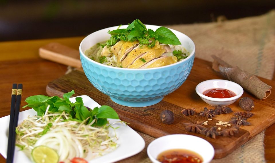 Bowl of Vietnamese pho with chicken and herbs.