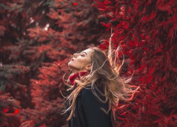 Woman enjoying nature in autumn forest.