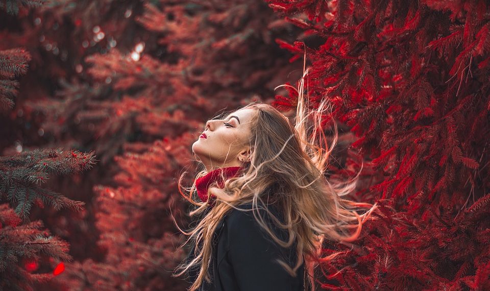 Woman enjoying nature in autumn forest.
