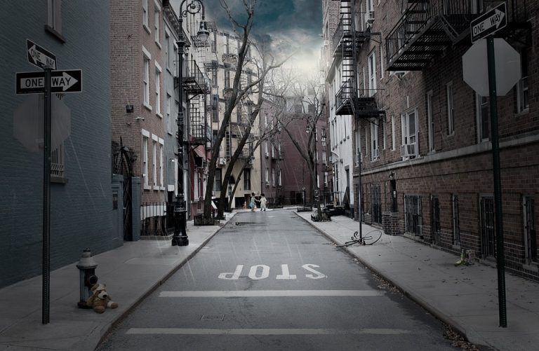 Deserted urban street with teddy bear under stormy skies.