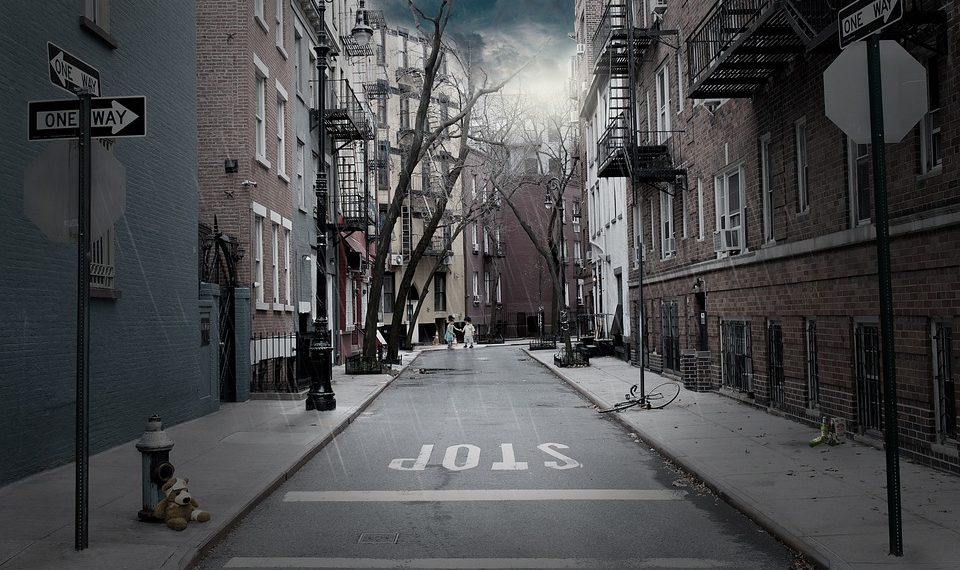 Deserted urban street with teddy bear under stormy skies.