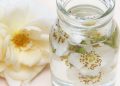 Jar of floral-infused water with rose petals.