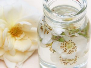 Jar of floral-infused water with rose petals.