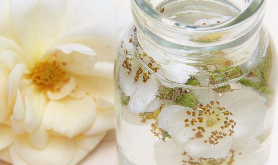 Jar of floral-infused water with rose petals.