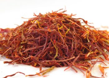 Dried saffron strands on white surface.