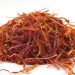 Dried saffron strands on white surface.