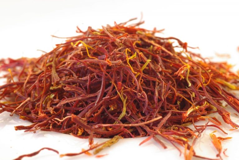Dried saffron strands on white surface.