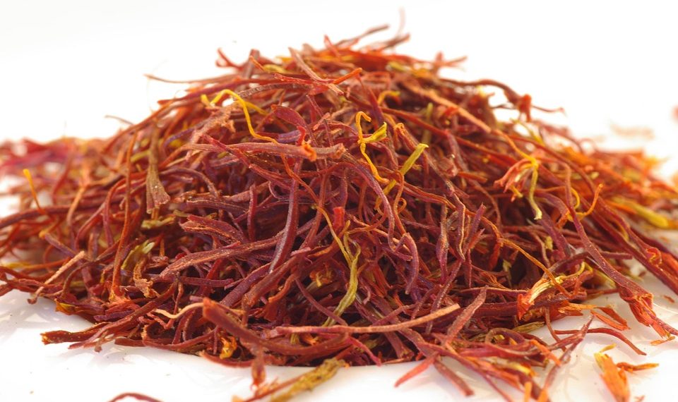 Dried saffron strands on white surface.
