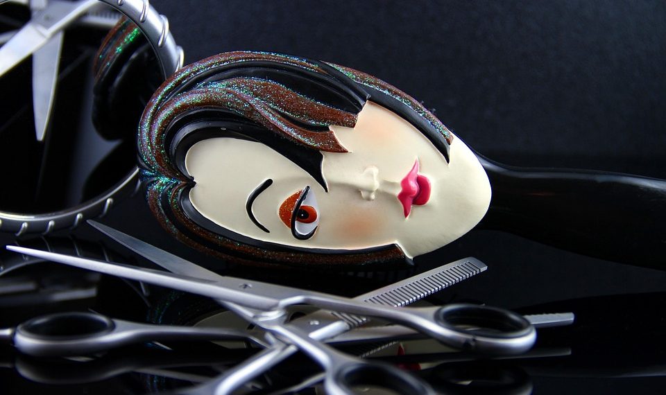 Comb featuring a stylized face with scissors on a reflective surface.