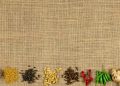 Spices and herbs arranged on burlap background.