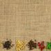 Spices and herbs arranged on burlap background.