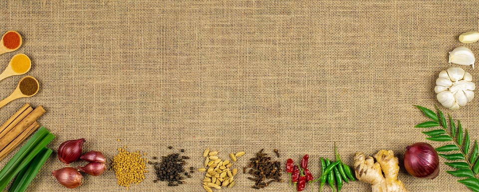 Spices and herbs arranged on burlap background.