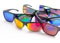 Colorful reflective sunglasses arranged on white surface.