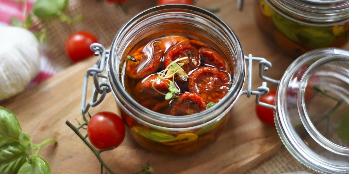 Sun-dried tomatoes preserved in olive oil in a glass jar.