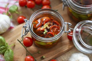 Sun-dried tomatoes preserved in olive oil in a glass jar.