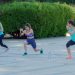 Women doing outdoor lunges in a sunny park workout.