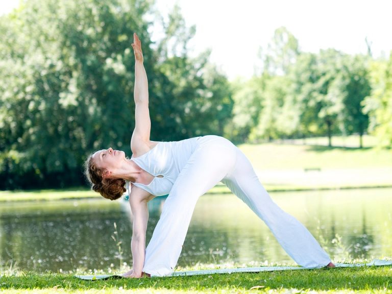 Woman practicing outdoor yoga in a park.