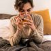 Woman enjoying a warm herbal tea in bed.