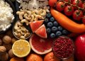 Assorted fresh fruits, nuts, and vegetables arranged beautifully for a healthy diet.