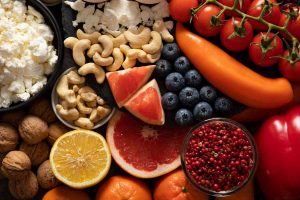 Assorted fresh fruits, nuts, and vegetables arranged beautifully for a healthy diet.