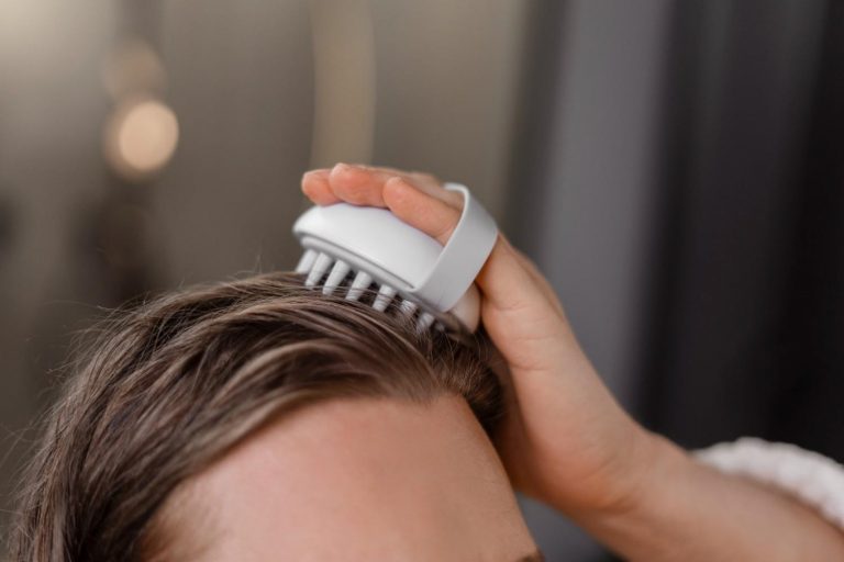 Scalp massage with handheld brush for relaxation.