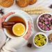 Cozy herbal tea with lemon and cinnamon, accompanied by dried flowers and cookies.