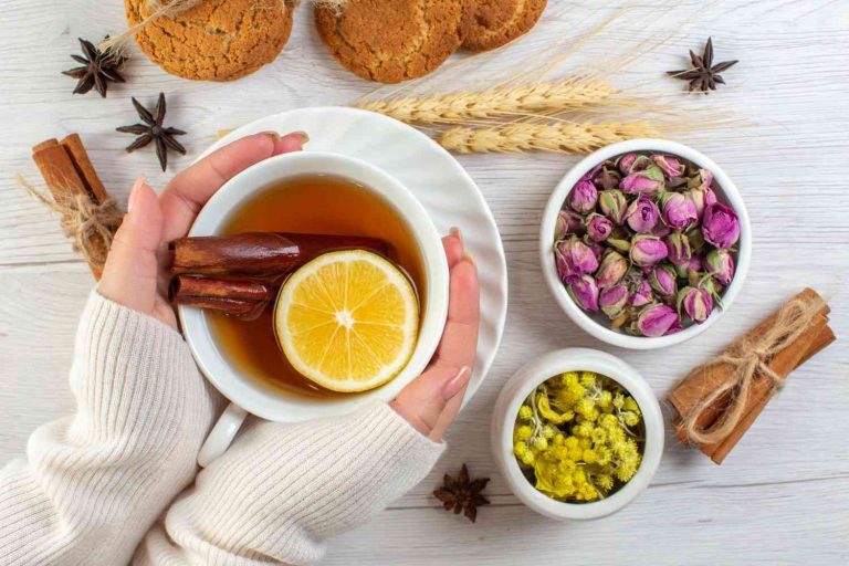 Cozy herbal tea with lemon and cinnamon, accompanied by dried flowers and cookies.