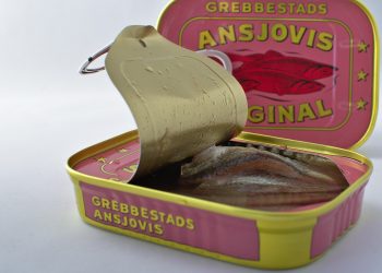 Open can of Grebbestads anchovies showing fish fillets inside.