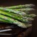 Fresh asparagus spears on a wooden cutting board.