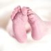 Newborn baby feet on soft white blanket.