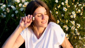 Young woman enjoying a sunny day among blooming daisies.