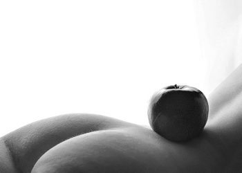 Apple balanced on serene body curve in black and white.