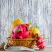 Tropical fruits in a basket against a rustic wooden background.