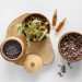 Dried herbs and essential oils in wooden bowls for aromatherapy.