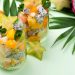 Tropical fruit salad in glasses with starfruit slices and mint.