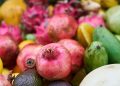 Assorted fresh tropical fruits including pomegranates and dragon fruits.