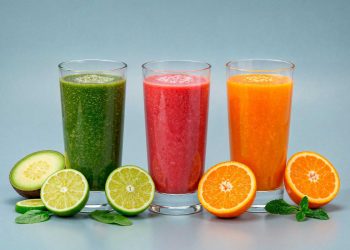 Three colorful smoothies with fresh fruits and mint leaves.