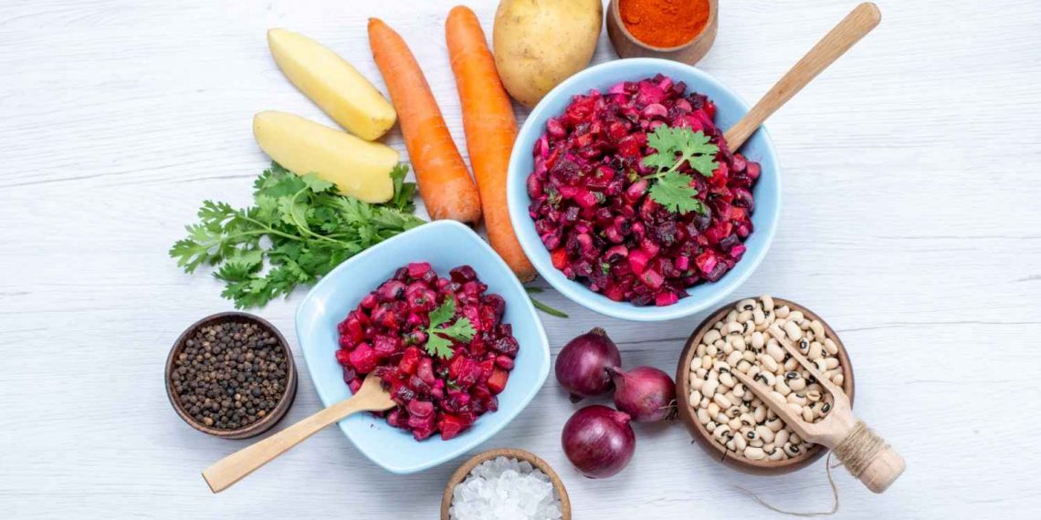 Healthy beetroot salad with fresh ingredients on a wooden table.