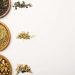 Assorted loose-leaf teas in wooden bowls on a white background.