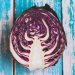 Sliced red cabbage on rustic blue wooden background.