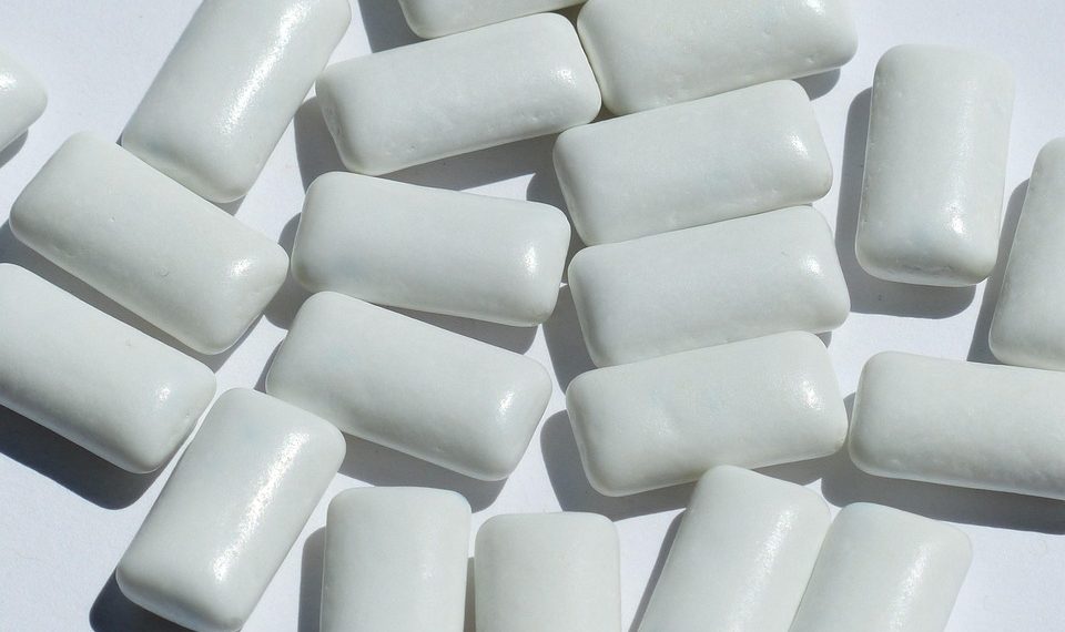 Chewing gum pieces scattered on a white surface.