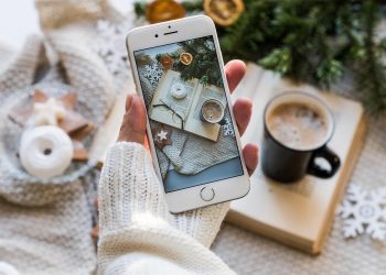 Cozy winter scene captured on smartphone with coffee and book.