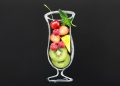 Mixed fruit smoothie in a glass outline with cherries, strawberries, and kiwi slices.