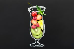 Mixed fruit smoothie in a glass outline with cherries, strawberries, and kiwi slices.