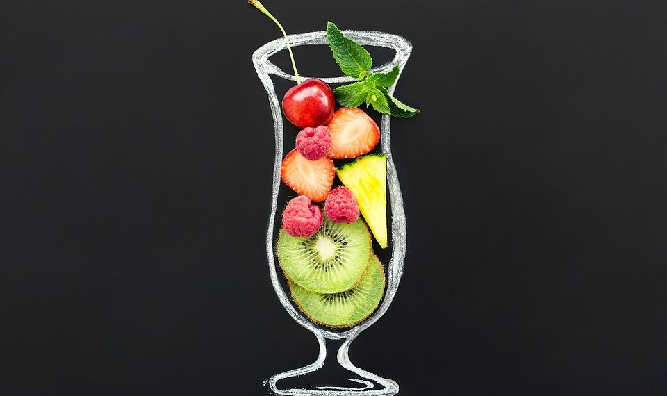 Mixed fruit smoothie in a glass outline with cherries, strawberries, and kiwi slices.