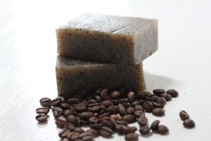 Natural coffee soap bars with coffee beans scattered nearby.