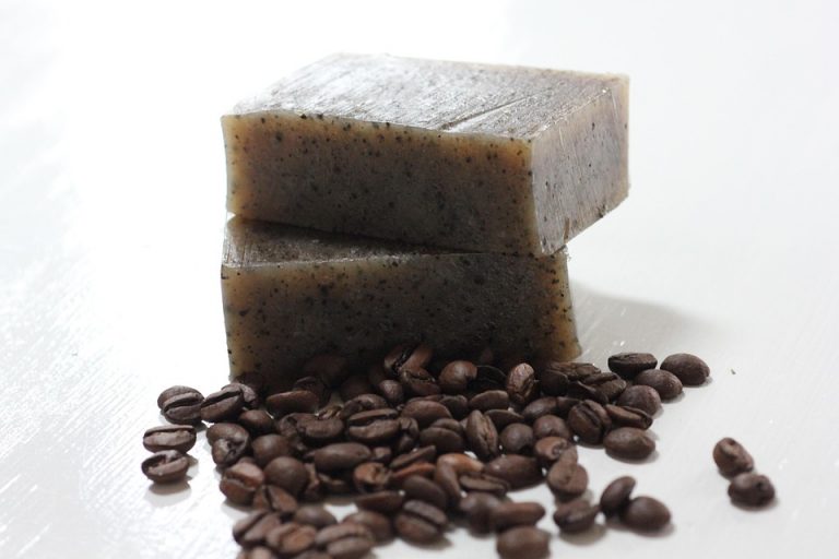 Natural coffee soap bars with coffee beans scattered nearby.
