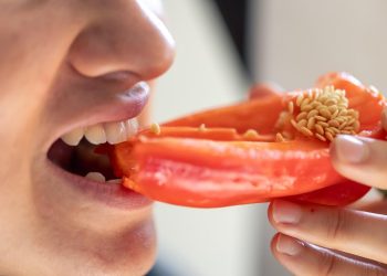 Eating a fresh red bell pepper.