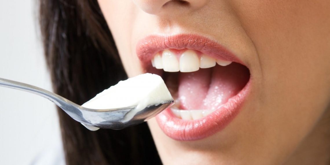 Eating yogurt with a spoon, close-up view.