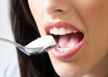 Eating yogurt with a spoon, close-up view.